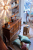 Antique sideboard against brick wall with shelves in niche