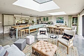Country-house kitchen, dining and seating areas below skylights in open-plan interior