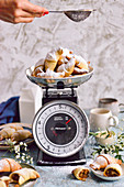 Brittle croissants in powdered sugar on a kitchen scale