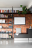 Bookcase with library ladder against brick wall in living room