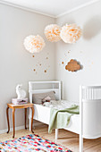 Pompons überm mitwachsenden Kinderbett im Kinderzimmer