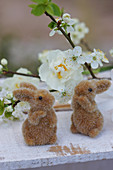 Little Easter bunnies in front of narcissus and cherry blossom