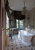 Free-standing bathtub, chandelier and curtains in French-style bathroom