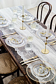 Bistrostühle am gedeckten Tisch mit Tischdecke aus Spitze