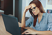 Unhappy woman using laptop