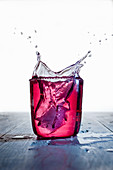 Roter Drink mit Splash vor weißem Hintergrund