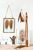 Arrangement in shades of brown with real feathers in glass frames
