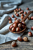 Hazelnuts on a wooden spoon and on a wooden table