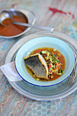 Loup de mer on a vegetable ragout with tomato and mace sugo