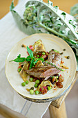 Rare seared lamb fillet with an artichoke and pea ragout