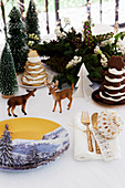 Christmas arrangement with china plate painted with winter landscape motif on table