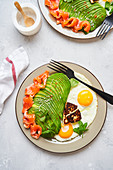 Healthy breakfast with fried eggs, salmon and avocado