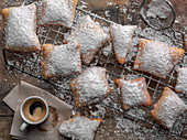 Beignets coated with powdered sugar and a cup of espresso