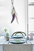 Dried grasses on wall above set Easter table