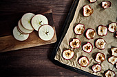 Fresh and dried apple rings on a baking tray