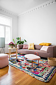 Scatter cushions on sofa, houseplants and side tables on multicoloured rug