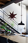 Pendant lamp and star decoration above pale dining table