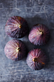Four fresh figs on a gray background