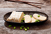 A piece of tempeh, partially sliced