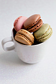 Verschiedenfarbige Macarons in weisser Tasse