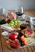 Vorspeisenplatte mit Salami, Käse, Obst, Gemüse, Brot und Wein