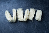 Uncooked rice noodles rolled in nests