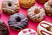 Verschiedene Donuts auf rosa Hintergrund