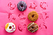 Variety of doughnuts on pink background