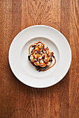 A brownie with cream, pecan nuts and caramel sauce