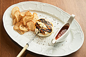Grilled chicken burger with crispy baked bread chips and BBQ sauce on plate