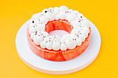 Zitruskuchen mit roter Spiegelglasur und weisser Zuckerdekoration