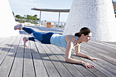 A brunette woman performing a plank