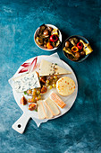 Cheese platter with fruit and marinated vegetables in small bowls