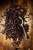 Coffee beans with a vintage spoon on a wooden background