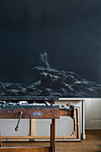 Dark painting on easel in artist's studio
