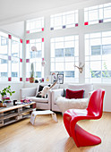 Red designer chair in living room with stained-glass window elements