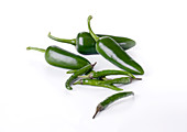 Various green chillies on a white background