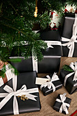 Christmas presents wrapped in black paper with white ribbons