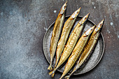 Smoked saury on a metal plate top view