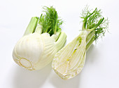 Fresh fennel, whole and halved on a white background