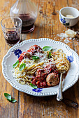 Spaghetti with tomato sauce and tuna meatballs, basil, parmesan, red wine