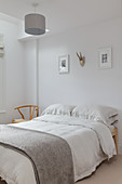 Simple double bed in bedroom with white walls