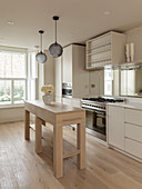 Simple, narrow kitchen island in pale wood in white, timeless kitchen