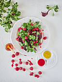 Composition of appetizing salad with ripe raspberry green spinach and aromatic sauce