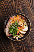 Ramen and noodles and vegetables serving in bowl on wooden table