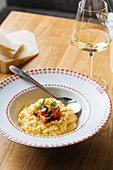Appetizing risotto with pumpkin, sliced tomatoes and green