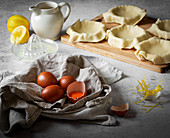 Pastry tart cases uncooked with brown eggs and lemon