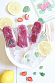 Berry popsicles with ice cubes and lemon