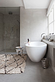 Free-standing bathtub and Oriental accessories in modern, grey and white bathroom