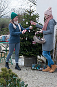 Women decorate Nordmann fir with stars and balls